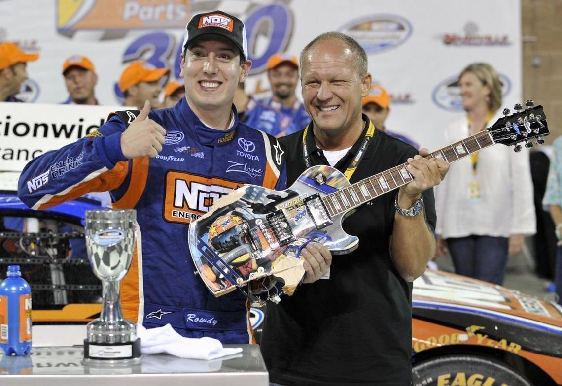In 2009 Kyle Busch posed with Sam Bass, right, the artist who painted the guitar trophy given to Busch after he won the NASCAR Federated Auto Parts 300 Nationwide Series auto race in Gladeville, Tenn.