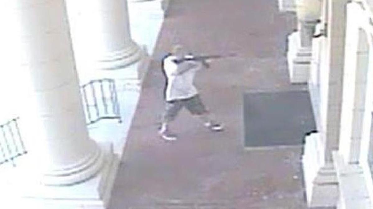 Surveillance video shows a man believed to be Kurtis Eugene Russell raises a rifle toward the door of the Anson County Courthouse on Aug. 18.