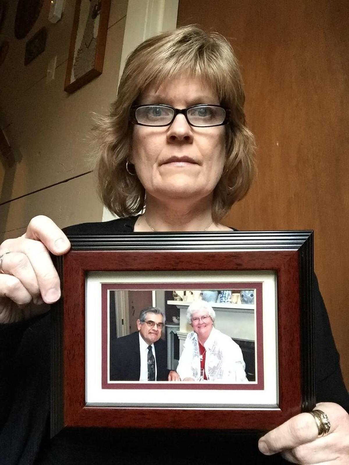 Kris Hauschildt holds a photograph of her parents, Daryl and Shirley Jenkins, who in 2013 were killed by leaking carbon monoxide in a Boone hotel.
