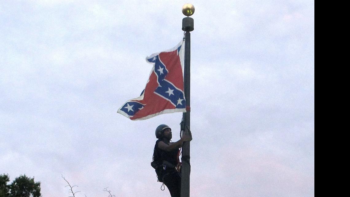 
Charlotte’s Bree Newsome climbs a flagpole to remove the Confederate battle flag at in front of the Statehouse in Columbia, S.C., on June, 27, 2015.


