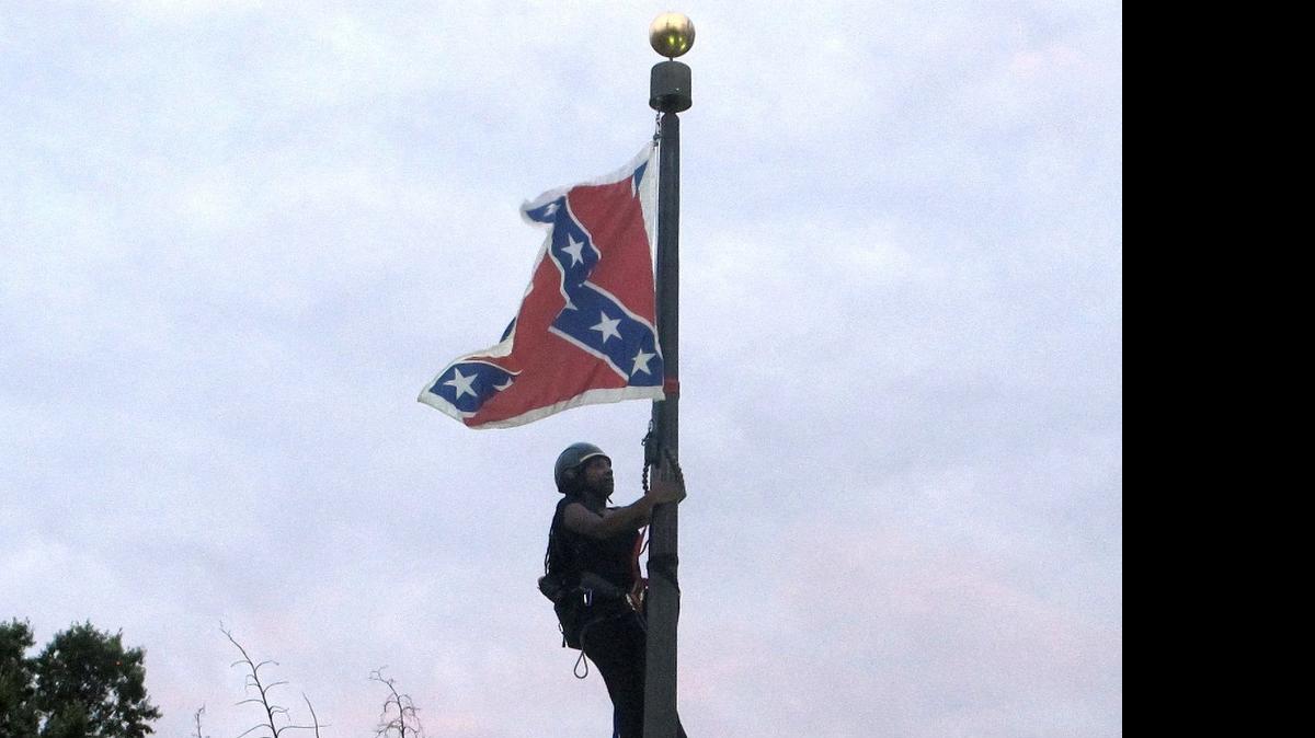 
Charlotte’s Bree Newsome climbs a flagpole to remove the Confederate battle flag at in front of the Statehouse in Columbia, S.C., on June, 27, 2015.


