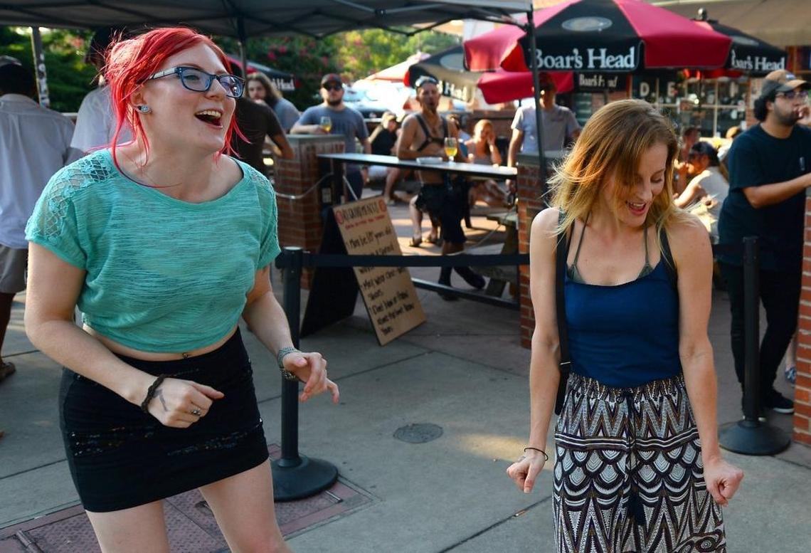 Kathryn Smith, left and Jennifer Kilbourne, celebrate an axe throw at the Common Market in Plaza Midwood.