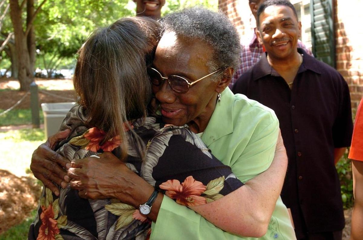 Lula Bell Houston (facing) gets a hug from Laura Jackson during her retirement party in front of the Davidson College laundry facility on April 29, 2004.