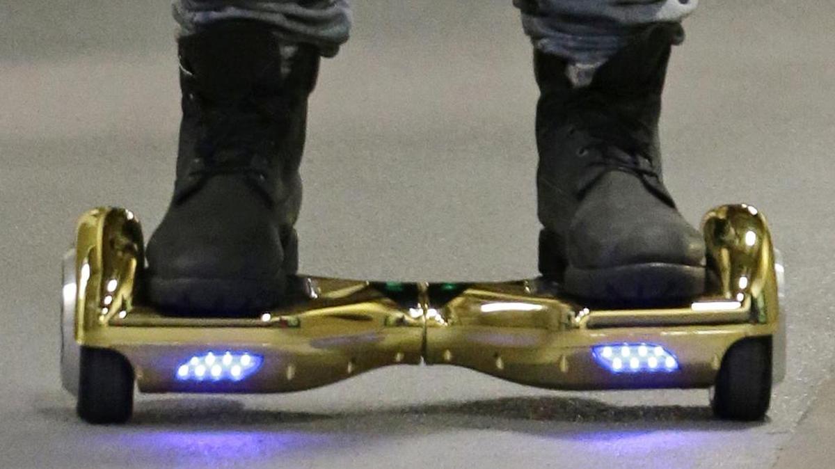 FILE - In this Oct. 5, 2015 file photo, Seattle Seahawks wide receiver B.J. Daniels rides through a hallway at CenturyLink Field on an electric self-balancing scooter commonly called a "hoverboard," as he arrives for an NFL football game against the Detroit Lions in Seattle. Since December 2015, several universities have banned or limited hoverboards on their campuses, saying the two-wheeled, motorized scooters are unsafe. Beyond the risk of falls and collisions, colleges are citing warnings from federal authorities that some of the self-balancing gadgets have caught on fire.