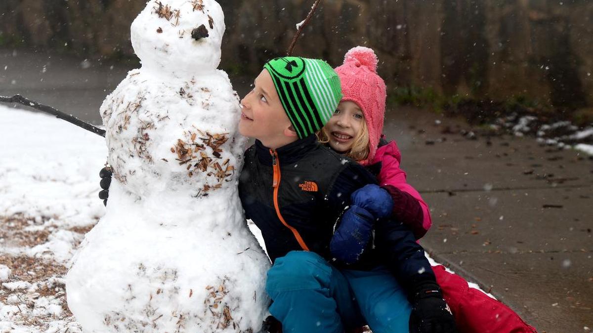 Jack and Kate Rook with a snowman they built at Latta Park during the March 12 snowfall in Charlotte.
