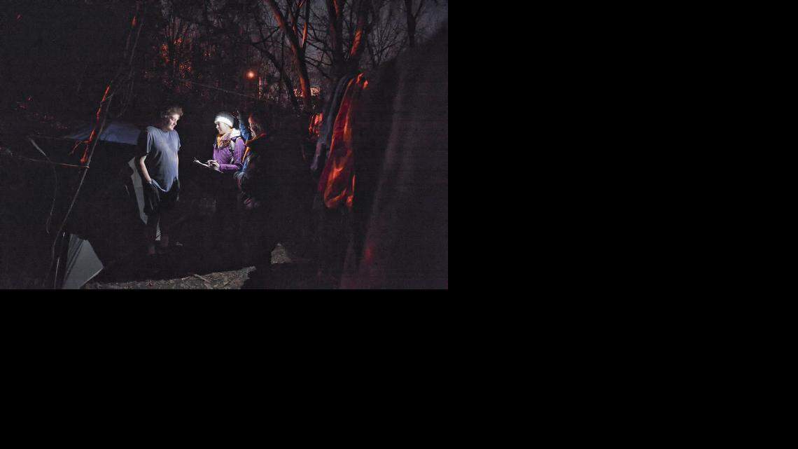 
Jeremy Mullin talks with Volunteers Lisa Higgins and Moira Quinn outside his tent near uptown Charlotte, Friday morning, Jan.30, 2015. 
