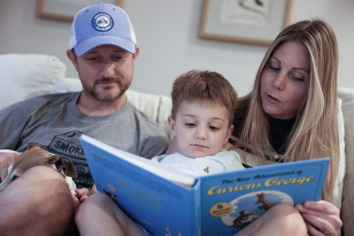 4-year-old Ellix Tiburtini, center, reads a Curious George book with his parents Mike Tiburtini, left, and Samantha at their Charlotte home on Wednesday, May 20, 2026.