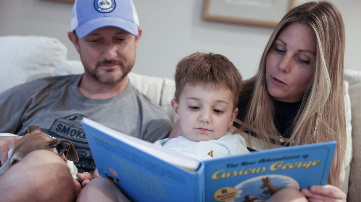 4-year-old Ellix Tiburtini, center, reads a Curious George book with his parents Mike Tiburtini, left, and Samantha at their Charlotte home on Wednesday, May 20, 2026.
