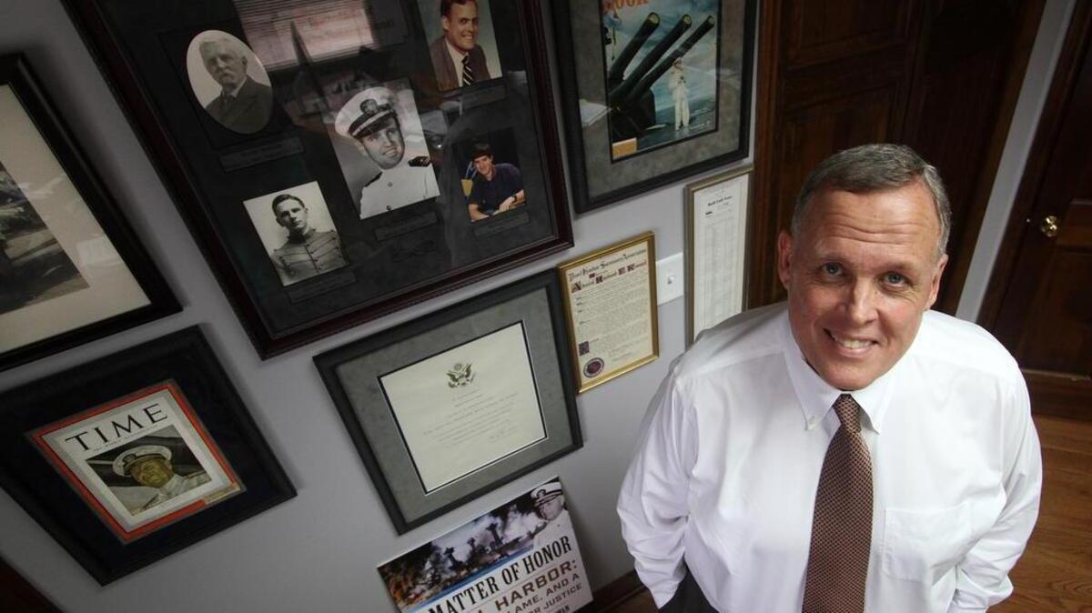 Manning Kimmel stands next to photographs of family, including his grandfather Admiral Husband Kimmel. Pres. Roosevelt accused Husband Kimmel of dereliction of duty after the Dec. 7, 1941 attack on Pearl Harbor. Manning Kimmel is continuing his efforts to have his grandfather’s name cleared.