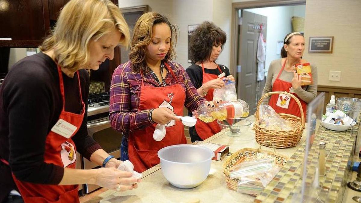 Volunteers Rhonda Aucamp, Alexandra Bell, Cathy Pruitt and Sharon Storck work together to prepare cookies for clients at the Ronald McDonald House. It’s one of the many nonprofits featured in the Observer’s Giving Guide.