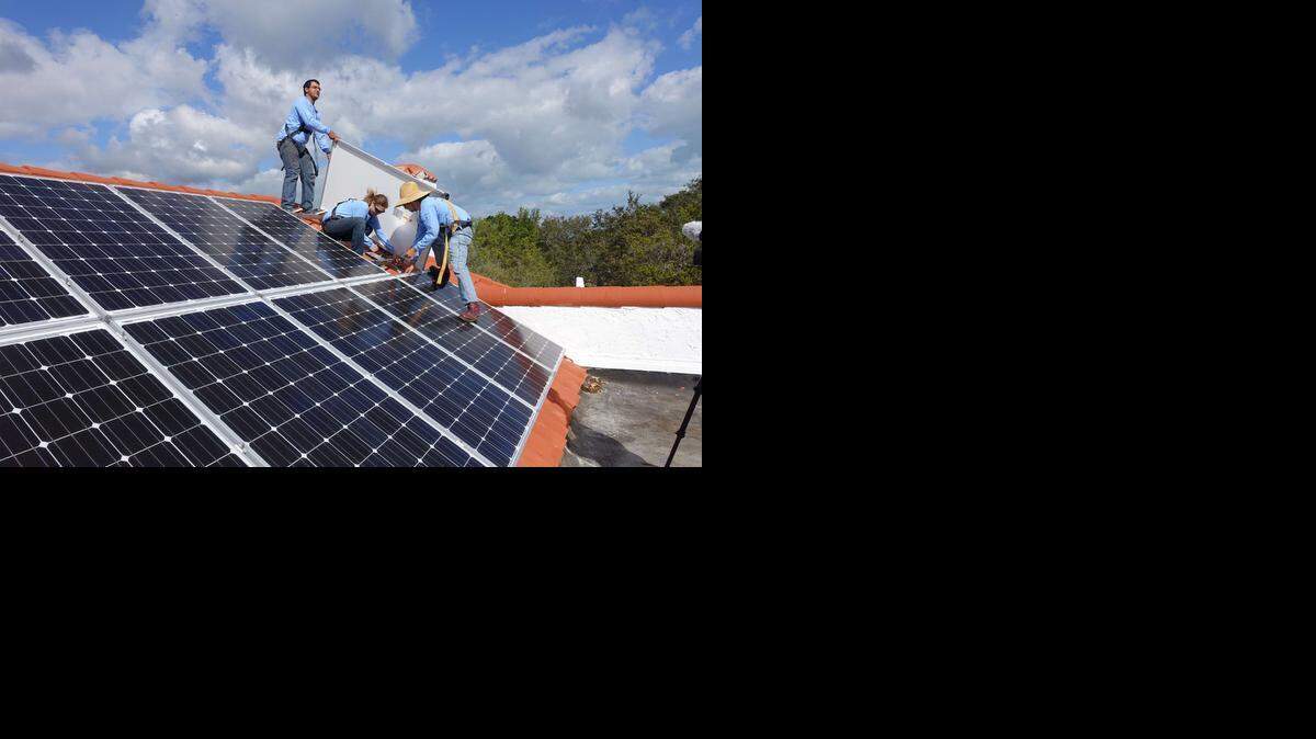 
Workers install solar panels on a rooftop on February 20, 2015 at a home in Palmetto Bay, Florida. AFP PHOTO /KERRY SHERIDANKERRY SHERIDAN/AFP/Getty Images
