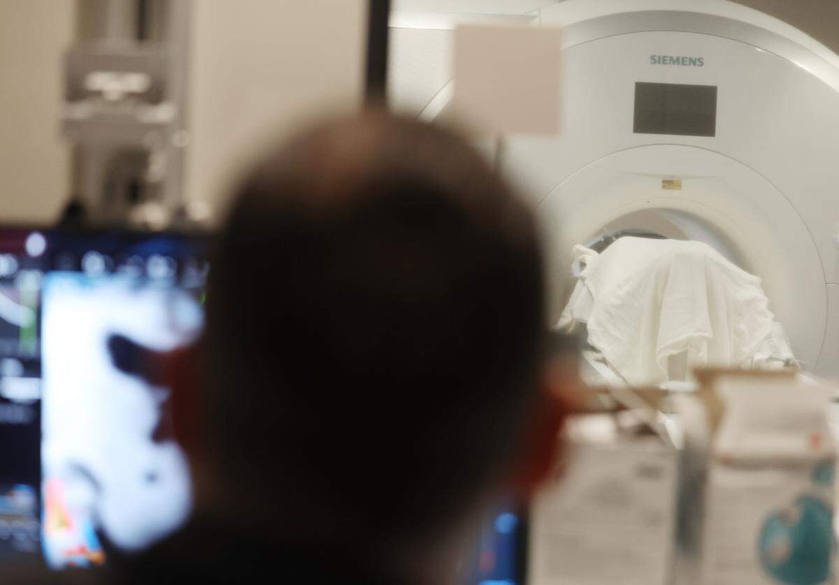 Neurosurgeon Dr. Charles Munyon works on a computer as patient Catherine Klie undergoes an incisionless brain procedure Monday in Mint Hill. 