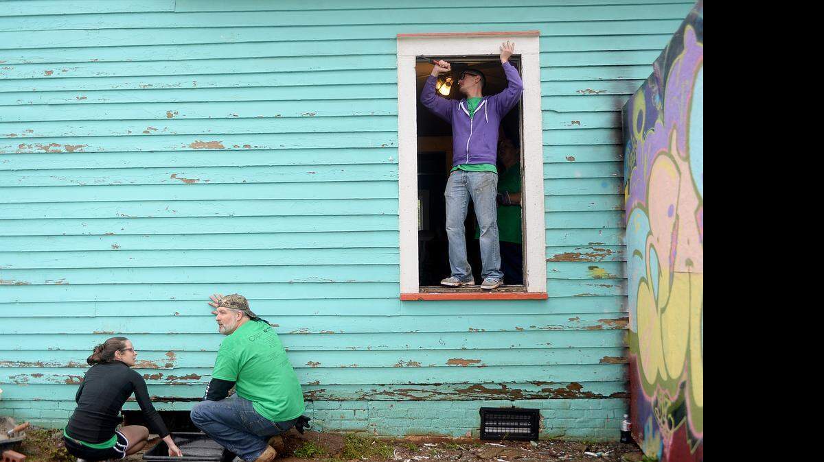 
Realtor volunteers Kelli Crigler, left, Nobie Thrasher, center, and Ian Leonard, right, work on exterior repairs at The Free Store on East 15th Street during Realtors Care Day. On Friday, more than 700 realtors participated in Realtors Care Day across Mecklenburg and Iredell counties, helping 25 homeowners and three Charlotte-area nonprofits with critical exterior repair needs. 
