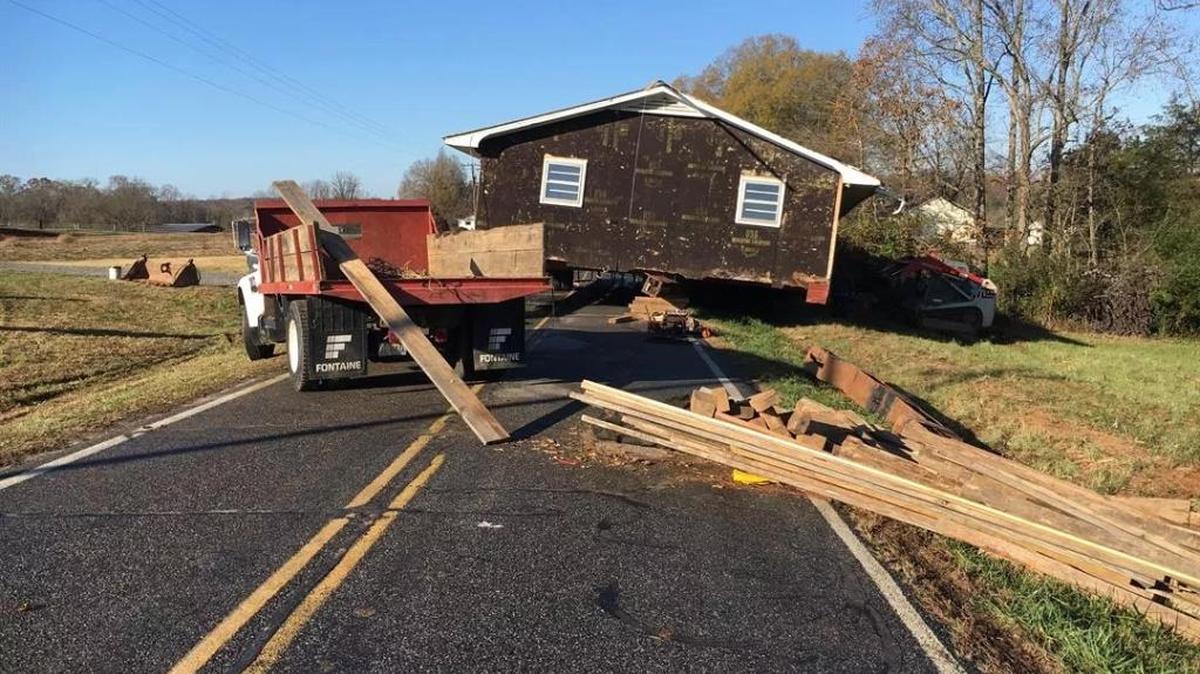A house being moved along Snow Creek Road in Iredell County came off the trailer and is blocking the road.