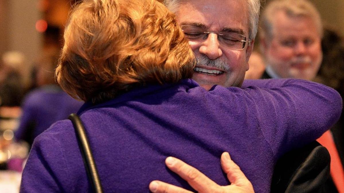 Ron Kimble, father of domestic violence victim Jamie Kimble, hugs people in the audience after giving closing remarks at the Women for Courage Luncheon on Wednesday at the Charlotte Convention Center. The Jamie Kimble Foundation for Courage was established by Ron and Jan Kimble “so that her memory may live and so that others can live.” The Foundation is committed to creating a future free of domestic violence.