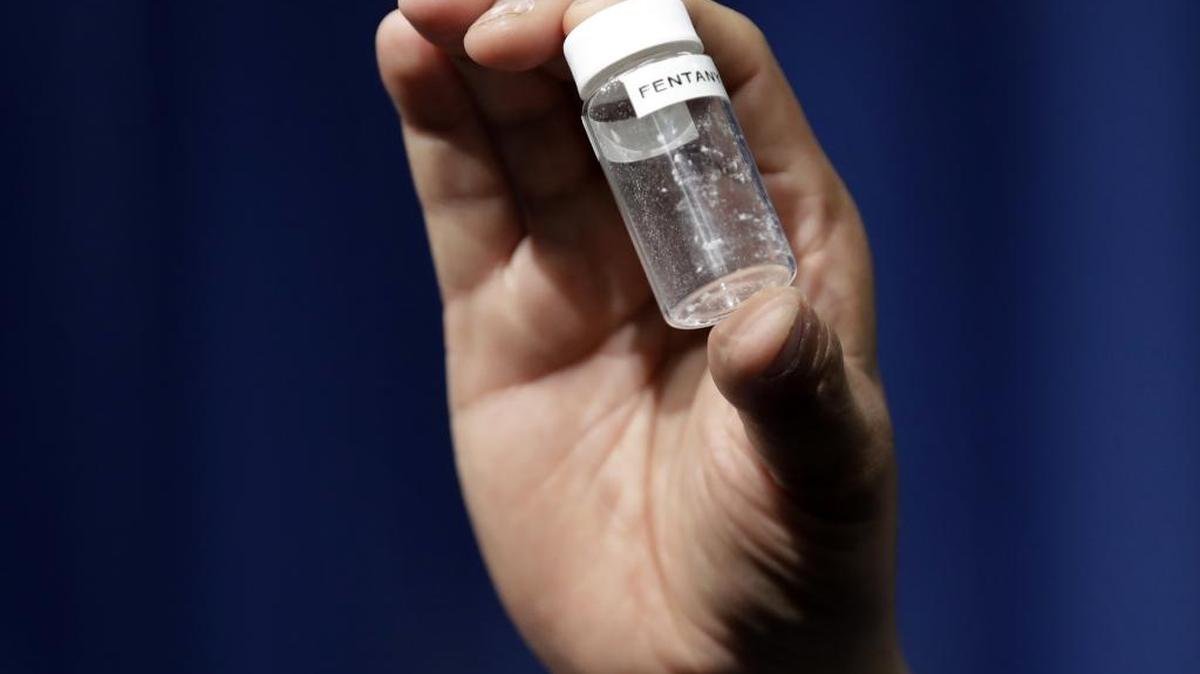 A reporter holds up an example of the amount of fentanyl that can be deadly after a news conference about deaths from fentanyl exposure, at DEA Headquarters in Arlington, Va.