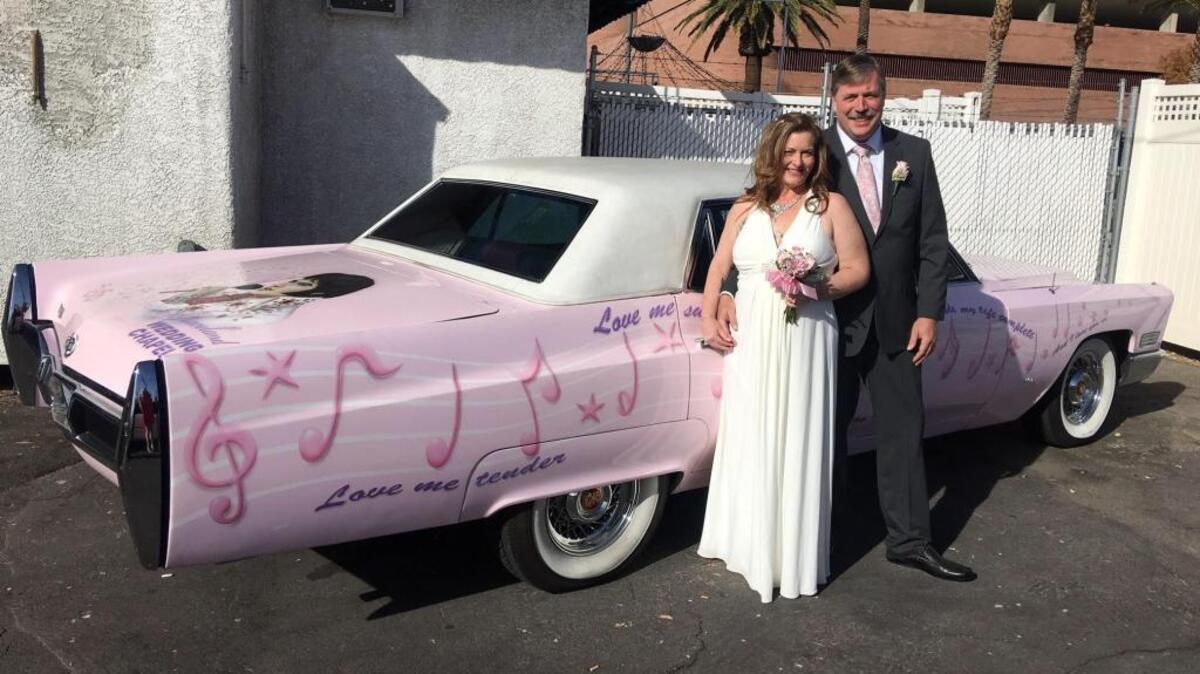 Rhonda Lennon and Brent Cheek pose with a pink Cadillac outside Graceland Wedding Chapel in Las Vegas, just before they said their vows.