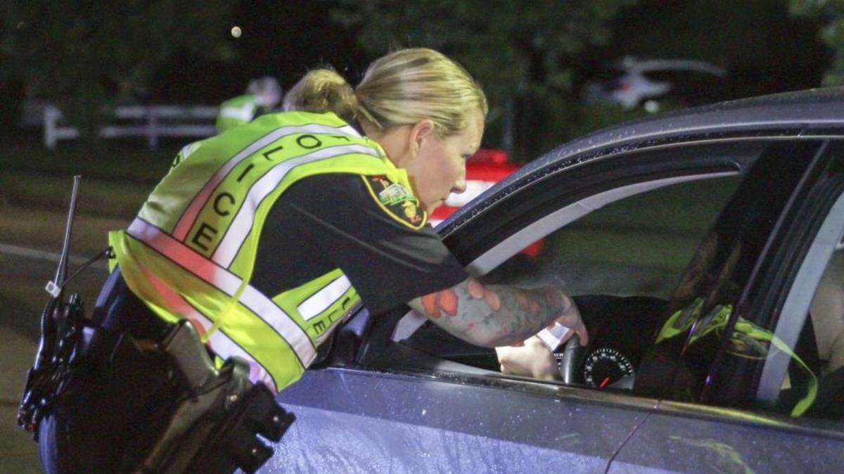 Officer Teresa Orr with the Jacksonville Police Department speaks with a driver at a checkpoint in Jacksonville, N.C. Efforts to prevent deadly encounters between police officers and motorists, young, black males in particular, have lawmakers across the country considering ways to teach teenagers how to react if stopped by police.
