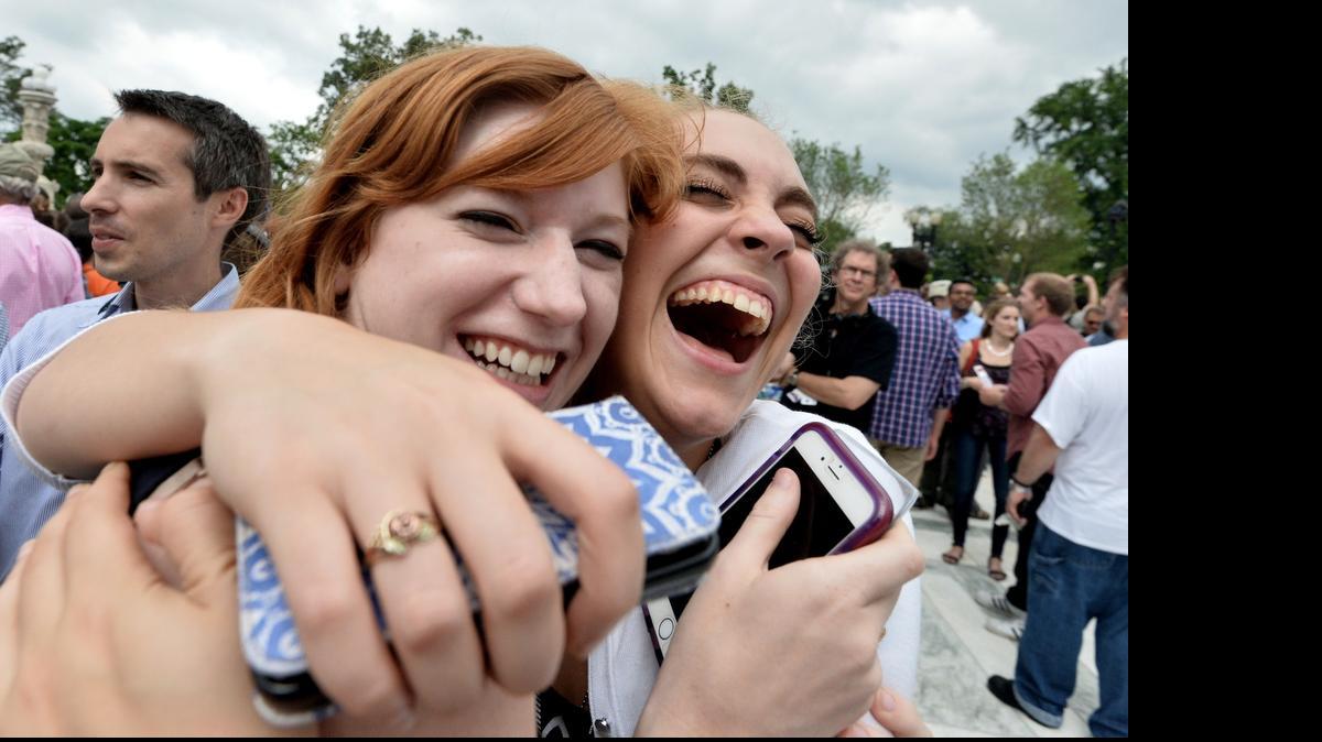 
Two women celebrate outside the Supreme Court in Washington DC on June 26, 2015 after its historic decision on gay marriage. The US Supreme Court ruled Friday that gay marriage is a nationwide right, a landmark decision in one of the most keenly awaited announcements in decades and sparking scenes of jubilation. The nation's highest court, in a narrow 5-4 decision, said the US Constitution requires all states to carry out and recognize marriage between people of the same sex. AFP PHOTO/ MLADEN ANTONOVMLADEN ANTONOV/AFP/Getty Images 
