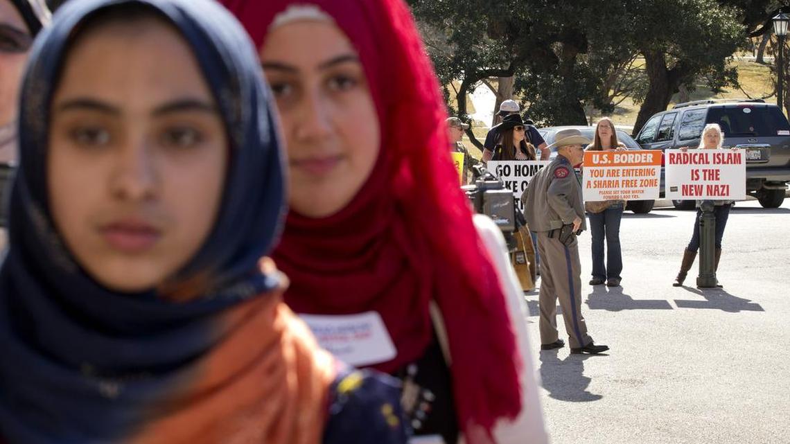 Fatima Burney, left, 14, and Marwa Qudah, 17, are faced with anti-Muslim protesters during the Texas Muslim Capitol Day in Austin, Texas, on Jan. 29, 2015. Hundreds of Muslims from around Texas gathered for the Council on American-Islamic Relations rally and to talk to their representatives about legislation that's important to them.
