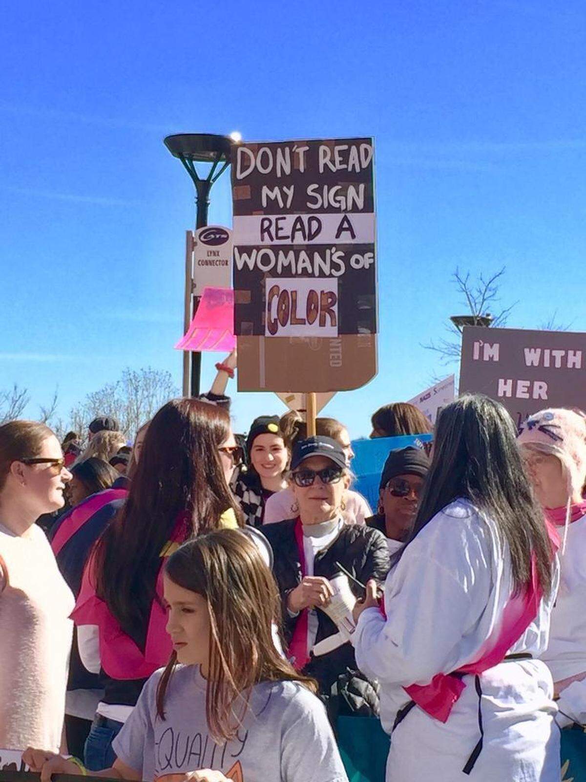 This sign, carried by a young white woman in the 2019 Charlotte Women United March, symbolizes the attempt to recognize women of color and others who may have been excluded in previous events.