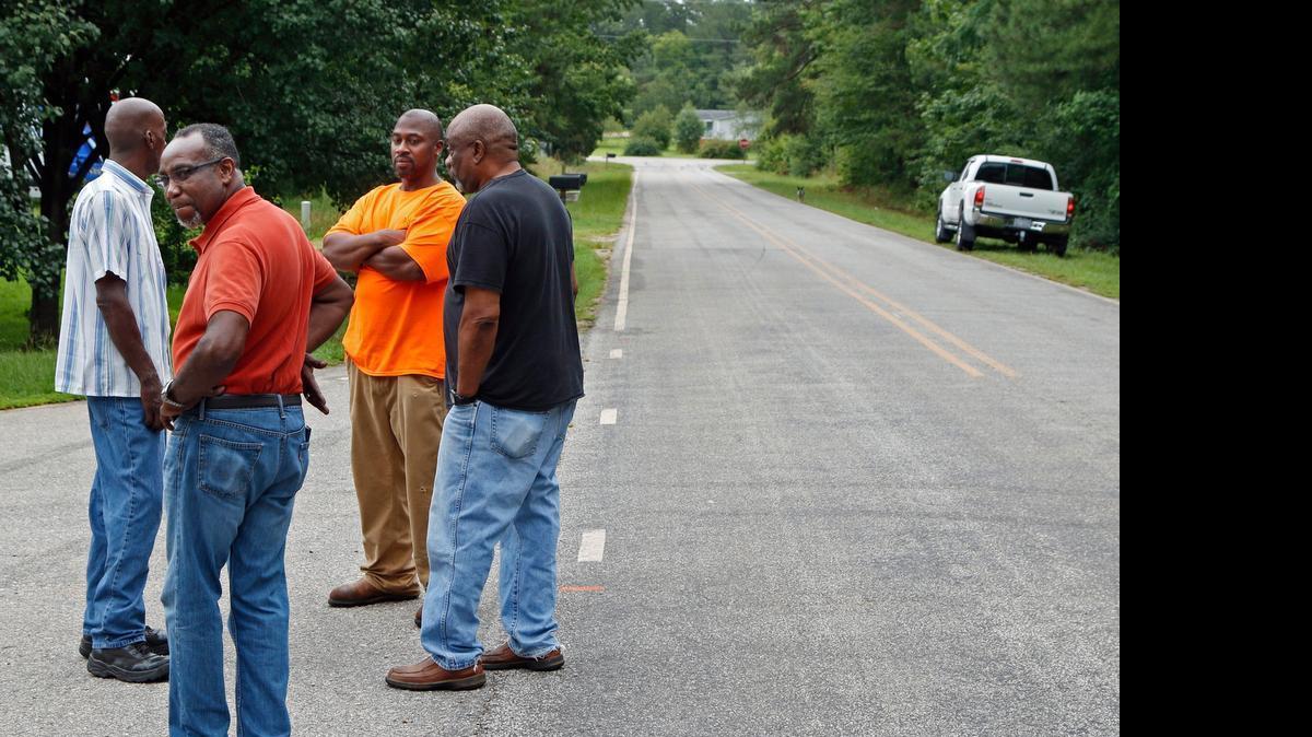 
From left, local residents Ricky Lynch, Billy O'Neal, Mike Roberts and Douglas Terry stop to talk quietly at the corner of Simon Road, right, and Buckhorn Drive just south of Middlesex in Johnston County Monday morning, July 13, 2015. A car that was drag racing Sunday evening ran off of Simon Road and into a crowd of bystanders that were at the intersection.
