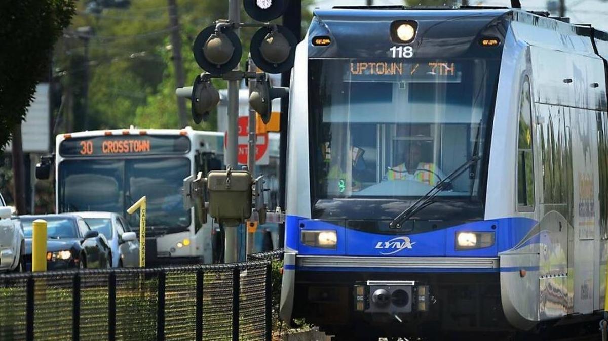 A CATS transit bus and LYNX light-rail train travel along South Boulevard in Charlotte.