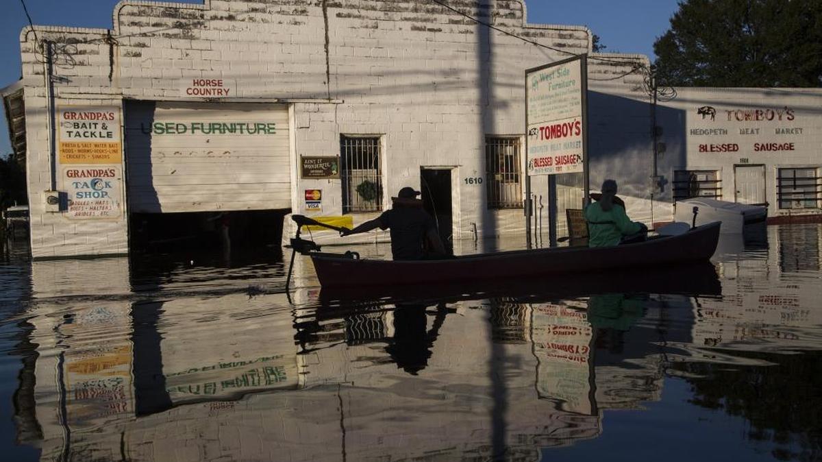 Ryan Christian and Delores Miller canoe down West Fifth Street after checking on Miller’s elderly mother’s home in downtown Lumberton after Hurricane Matthew caused downed trees, power outages and massive flooding along the Lumber River Tuesday,.