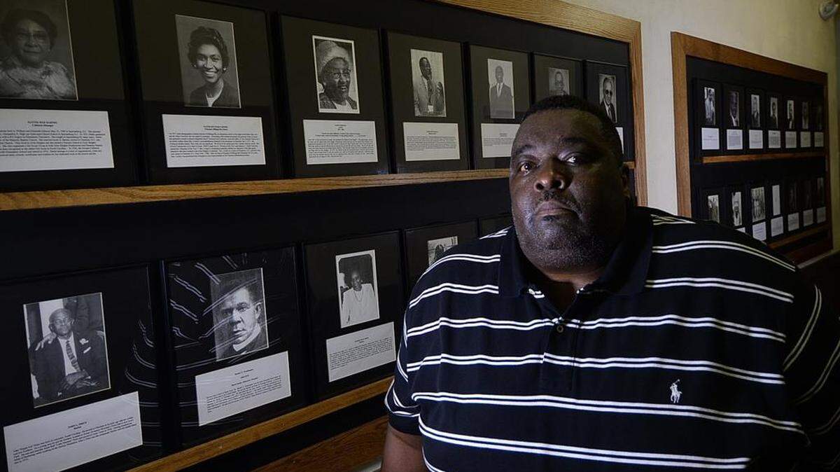 
Jonathan Belton in front of the Wall of Fame in the Grier Heights community’s  88-year-old Billingsville School, a historic Rosenwald school fully restored. Grier Heights will celebrate the 50th anniversary of its Labor Day homecoming and parade and the reopening of its beloved - and restored -Billingsville School on Monday.
