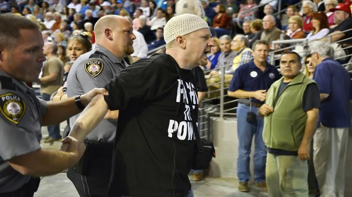 Charlotte’s Jibril Hough is escorted out while Republican presidential candidate Donald Trump speaks Saturday at a town hall meeting in the Convocation Center on the University of South Carolina Aiken campus.