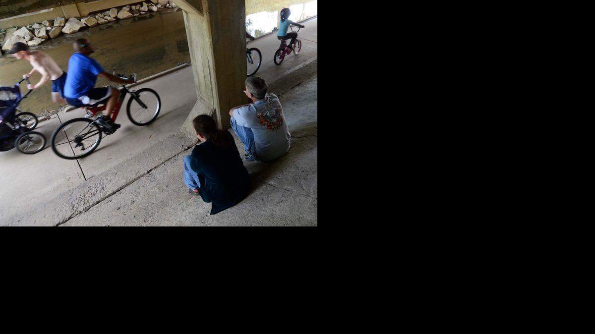 
Smokers puff away under the bridge on the Little Sugar Creek Greenway in 2012. 

