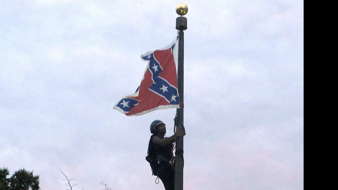 
Bree Newsome of Charlotte, N.C., climbs a flagpole to remove the Confederate battle flag at a Confederate monument in front of the Statehouse in Columbia, S.C., on Saturday, June, 27, 2015. She was taken into custody when she came down. The flag was raised again by capitol workers about 45 minutes later. 
