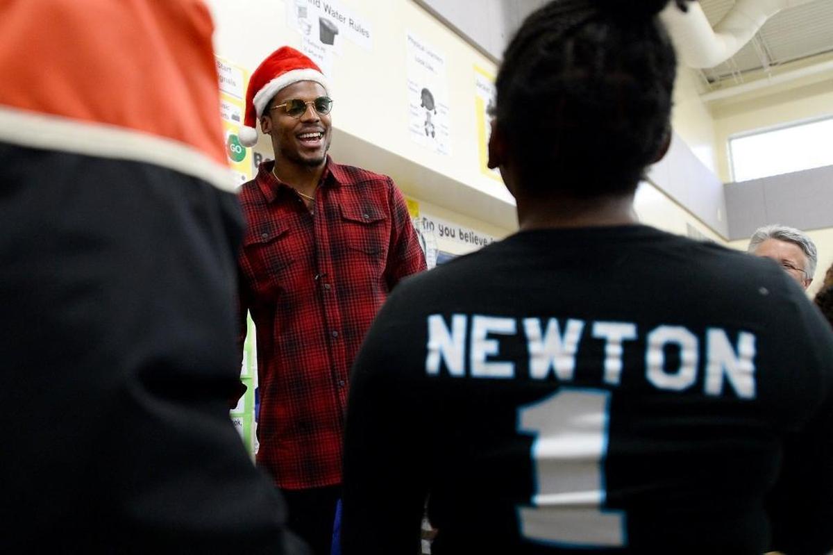 Carolina Panthers quarterback Cam Newton greets students and parents as he helps hand out canned goods during his Santa Cam’s Surprise Sleigh stop at Devonshire Elementary on Tuesday.