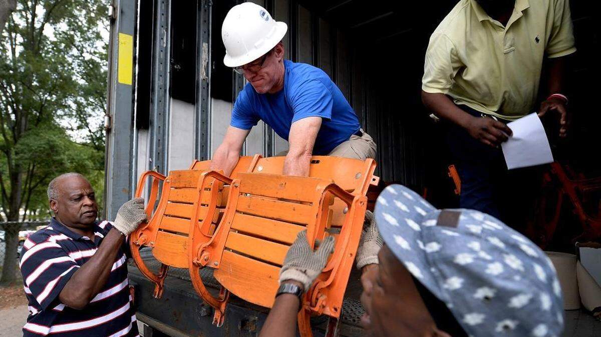 
(L-R) Jake Russell, Mike Pritchett, Antonio White and James Lowery unload a pair of old wooden seats from Bojangles Coliseum for a customer on Wednesday, September 9, 2015. The few hundred people lucky enough to get Bojangles seats during an online sign up earlier this year arrived to pick them up on Wednesday.


