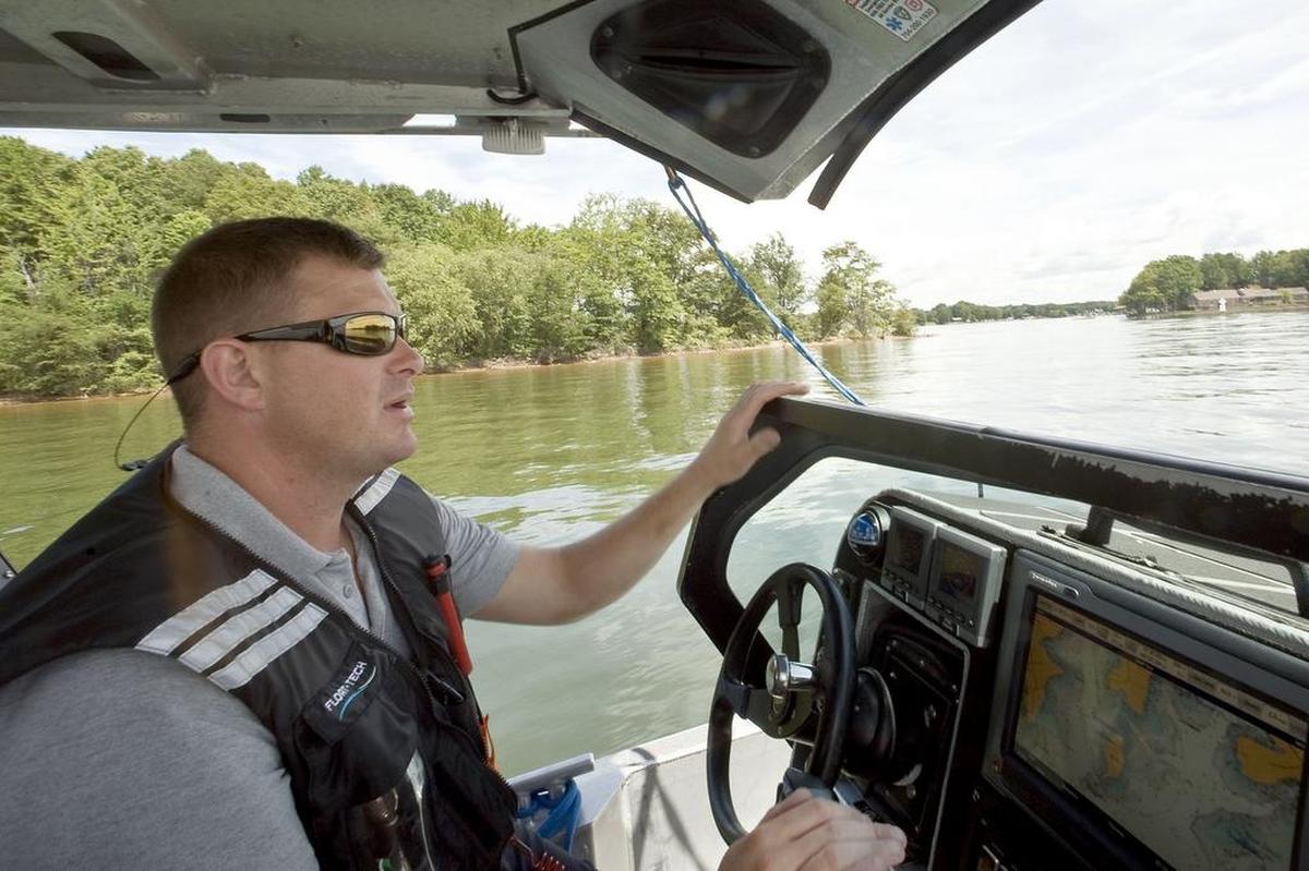 Sgt. George Brinzey, in charge of the Cornelius Police Department Lake Patrol, slowly navigates the shallow water of The Sandbaron August 19. His department is responsible for patrolling The Sandbar and enforcing the Lake Norman Marine Commission's Rafting Safety Ordinance and the regulations it provides.