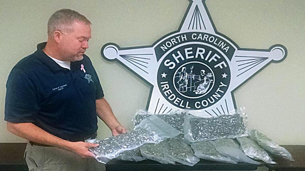 Iredell County Sheriff Darren Campbell examines the $100,000 in high-grade marijuana seized by sheriff’s narcotics investigators. The box containing the vacuum-sealed packages was intended for a home in Troutman, the sheriff said.