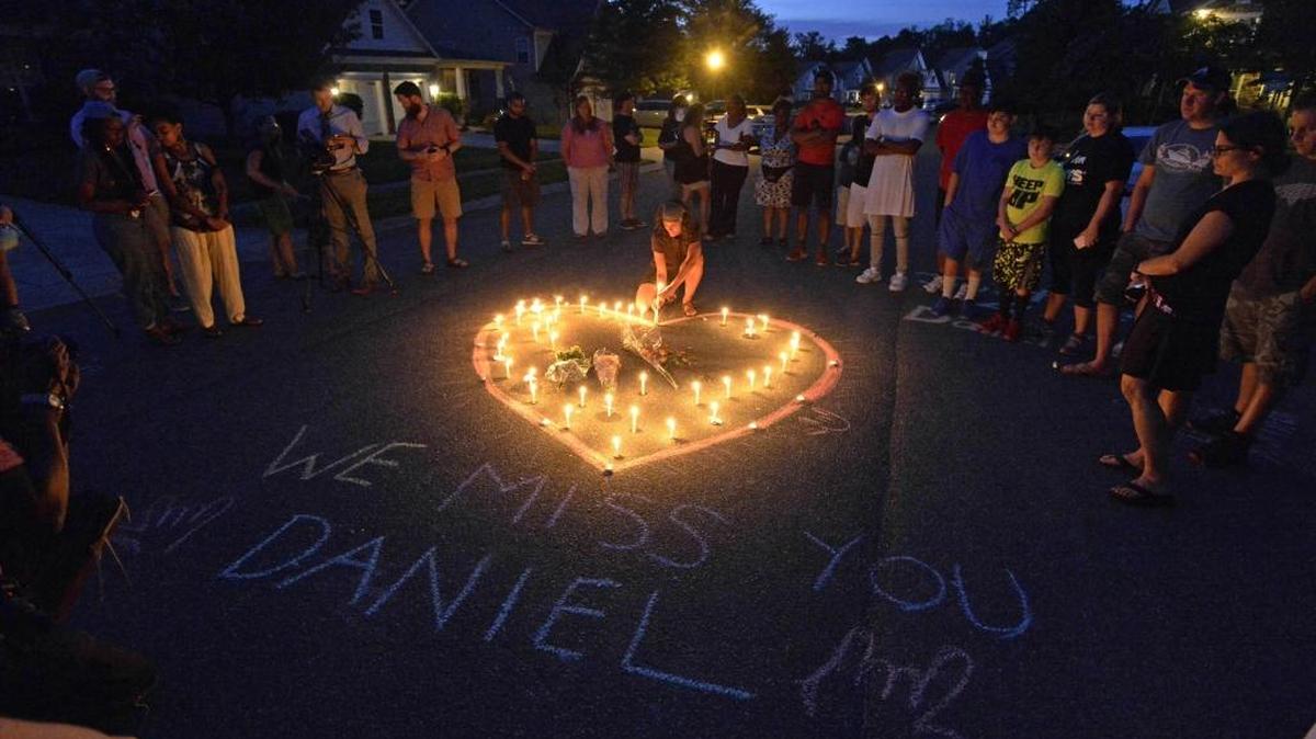 Friends and family of Daniel K. Harris gather around a heart drawn onto Seven Oaks Drive during a candlelight vigil on Monday to remember Harris, a deaf motorist who was shot and killed by a state trooper last week.