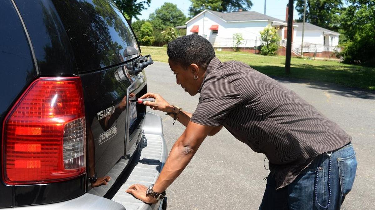 Former Observer writer Tonya Jameson shows how she was fastening her license plate onto her new Isuzu SUV purchased in Jefferson City, Tenn., when a Knoxville Police officer pulled a gun on her.