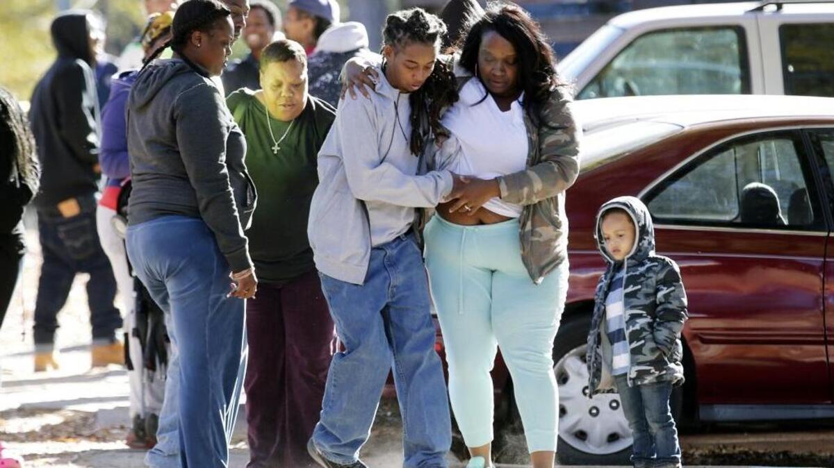 A woman overcome with emotion is led away from the scene near the location of a police officer-involved shooting at McDougald Terrance housing project in Durham, NC on Nov. 22, 2016.