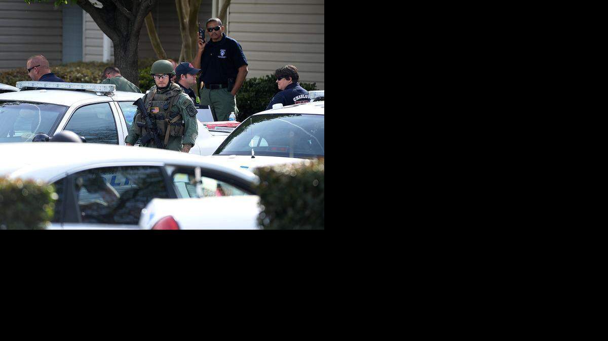 
A SWAT team member crosses a parking lot at the Mission Reedy Creek apartments on East W.T. Harris Boulevard near The Plaza on Sunday. After hours of trying to get the suspect in a fatal shooting to surrender, police entered the apartment and found the man dead of a self-inflicted gunshot.
