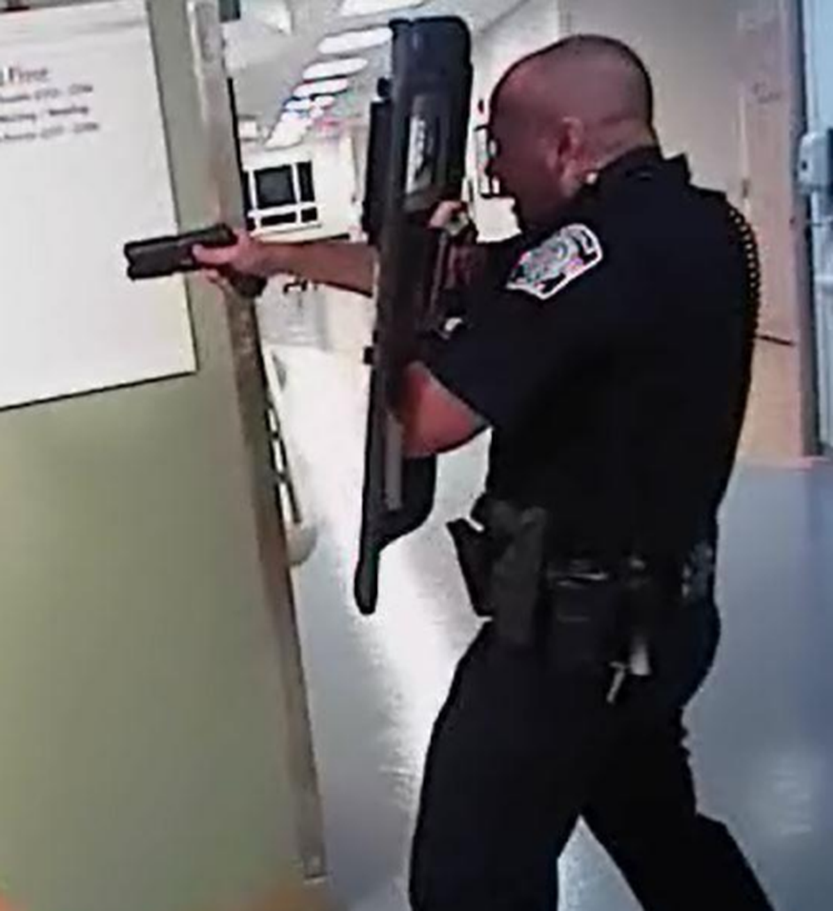 Huntersville police Officer Travis Watts aims his gun, moments before he and fellow officer Michael Joseph shot and killed James Cook in a Huntersville hospital on Sept. 10. Cook was an elderly hurricane evacuee from Florida who prosecutors say pulled a handgun from his suitcase and later aimed it at police.