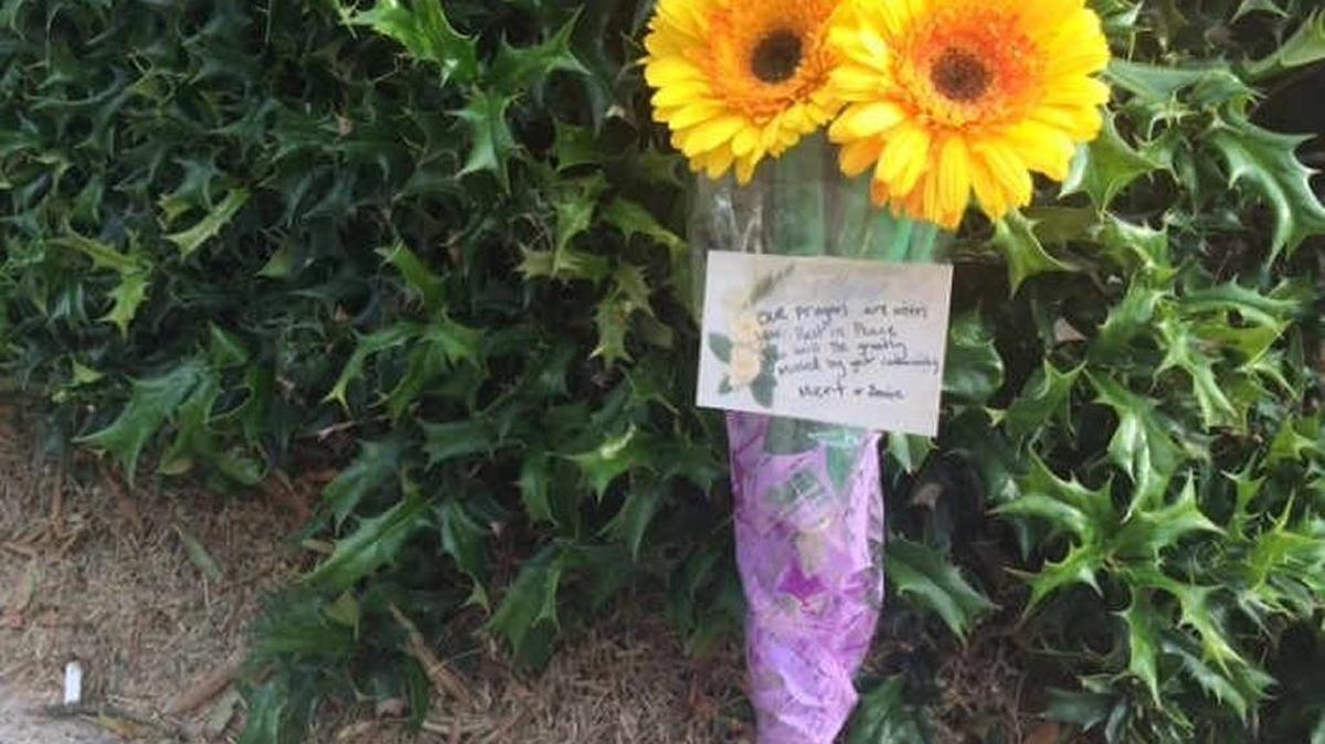 Flowers left in Plaza Midwood in memory of Katherine Memory Jones, 26, a hostess at Midwood Smokehouse on Central Avenue who was fatally shot several blocks away early Saturday.