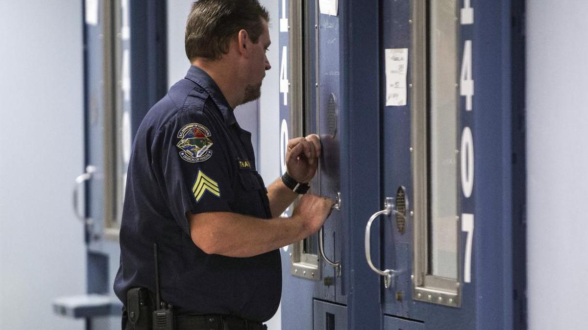 A corrections officer checks on an inmate Wednesday, August 5, 2015, at Central Prison’s treatment mall.