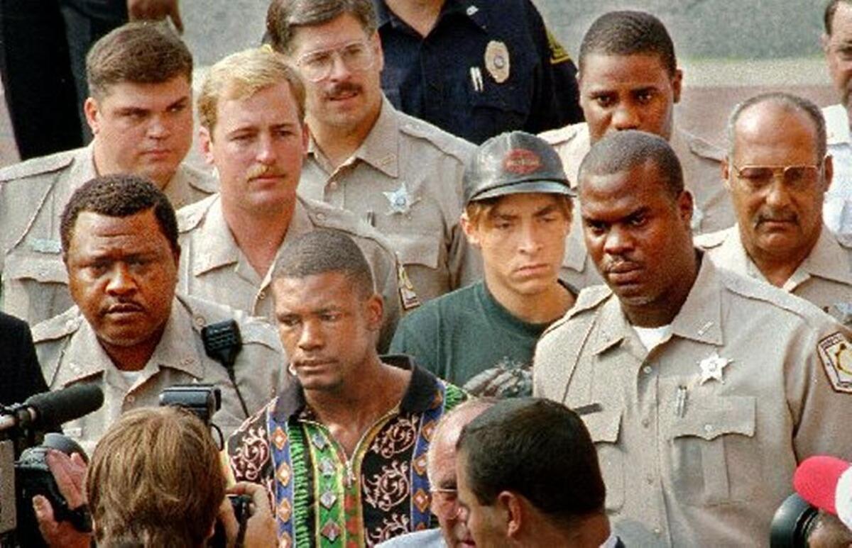 Daniel Green, left, and Larry Demery (center, right, in hat) are surrounded by Robeson County deputies after their 1993 arrests in connection with the murder of James Jordan. At trial, Demery said Green shot and killed Michael Jordan’s father during a robbery attempt. Green’s attorneys say he deserves a new trial.