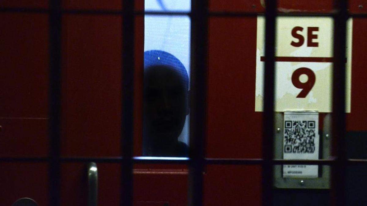 An inmate peers from his segregation cell at Lanesboro Correctional Institution.