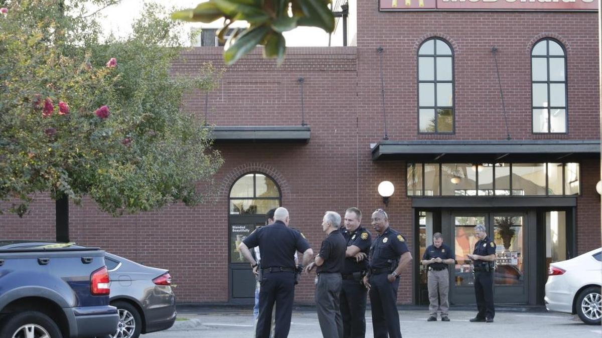 Police investigate at the scene following a lead of a man with a gun at a McDonald's in Tampa, Fla., Tuesday. Howell Emanuel Donaldson, 24, was charged with four counts of first degree murder in connection with deaths in the Seminole Heights neighborhood. Police detained the man earlier Tuesday after a tip that he had a gun at a McDonald's. (Gabriella Angotti-Jones/Tampa Bay Times via AP)