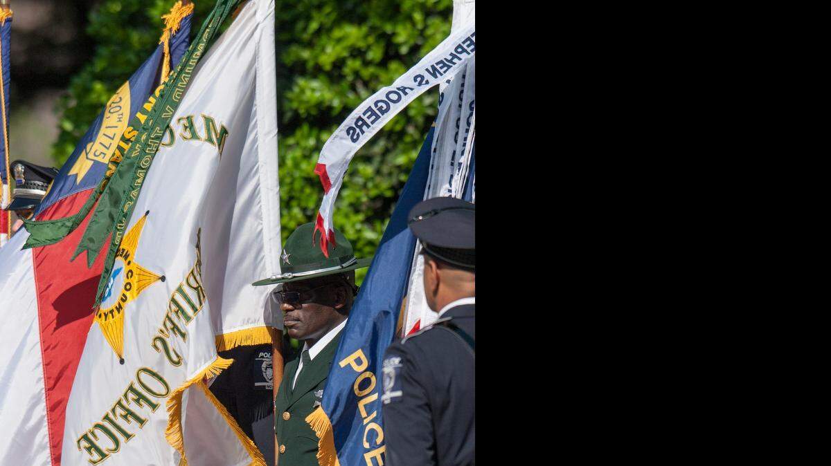 
A police officer waits for the color guard to form before the procession in Charlotte, NC on Friday May 8, 2015. 
