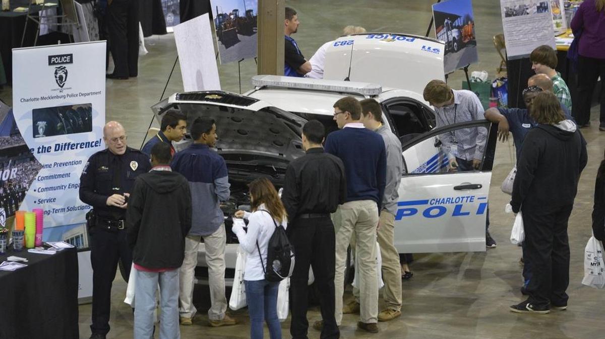 Students surround the Charlotte-Mecklenburg Police display as thousands of local high school students attended Discovery Day in April 2014, hosted by the Mayor's Youth Employment Program and Charlotte-Mecklenburg Schools. Reaching out to young people is one way police are trying to reduce Charlotte’s homicide rate in the long term.
