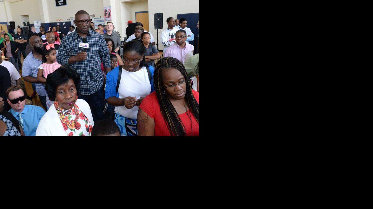 
Charlotte-Mecklenburg Police Chief Rodney Monroe surrounded by members of the audience watch as a participant from the audience takes part in a training simulator scenario at a community town hall meeting hosted by CMPD and NCLBA, NC Local Barbers Association, at Martin Luther King Middle School April 12,2015,the purpose of the town hall to create an open and honest dialogue on matters involving police and race relations.
