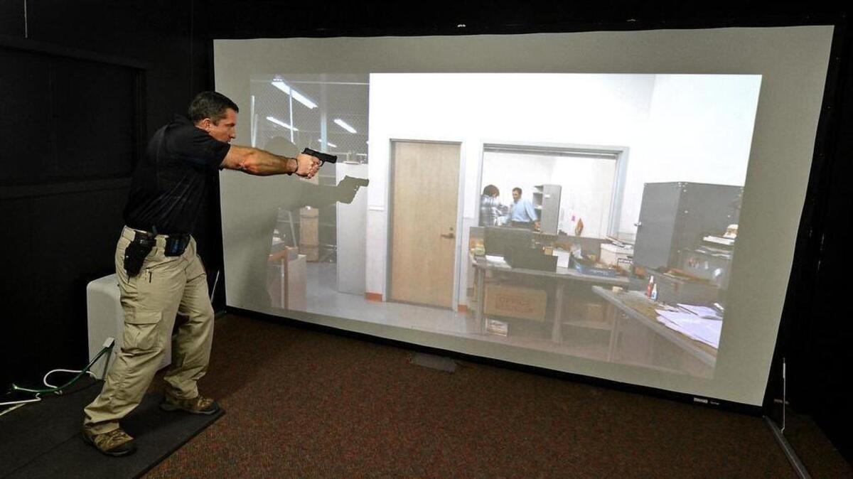 
Kip White, Assistant Range Master with the Firearms Training Unit demonstrates a scenario inside the Charlotte-Mecklenburg Police FATS simulator training facility on Wednesday, October 30, 2013. The simulator trains recruits to deal with potential use of force situations. Jeff Siner - jsiner@charlotteobserver.com
